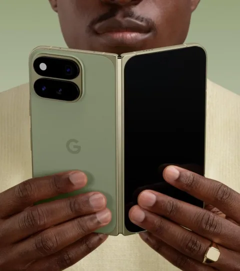Google Pixel 11 Pro Fold in Olive, unfolded in-hand with both hands, camera bar visible
