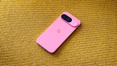 Google Pixel 9 in Peony lying face-down on a woven yellow fabric surface