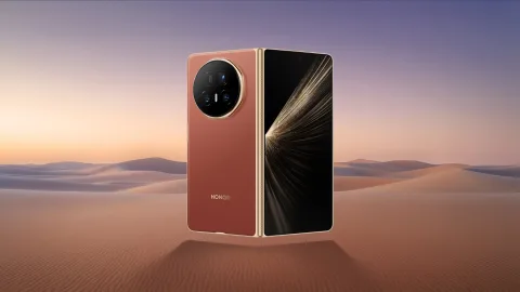 Honor Magic V5 folded, Orange colourway, standing on a beach