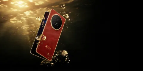 Honor Magic V6 in Red, partially folded and submerged in water showing the camera module