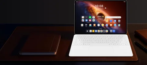 Honor MagicPad 4 with keyboard on a dark wood desk