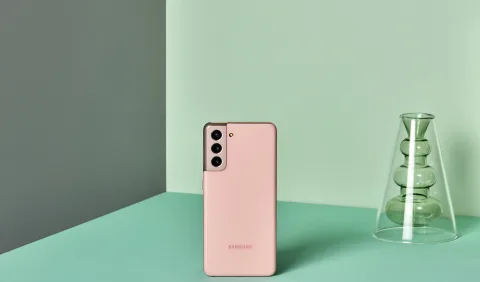 Samsung Galaxy S21 in Phantom Pink, standing on a lifestyle backdrop