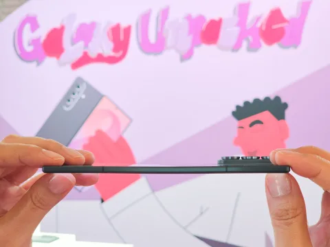 Samsung Galaxy Z Fold8 Ultra in Graphite, side profile held between fingers, showing its thin unfolded body at Galaxy Unpacked