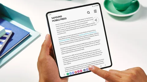Person holding an open Galaxy Z Fold5 showing the Samsung Mobile Press website