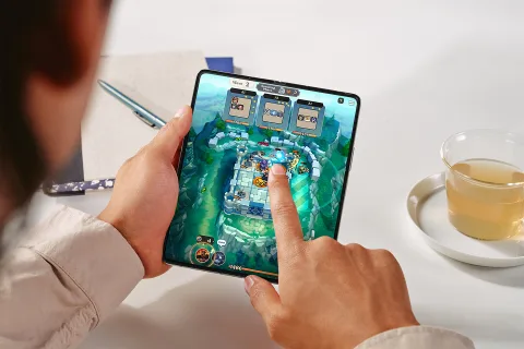 Person playing a game on an open Galaxy Z Fold5 held in two hands