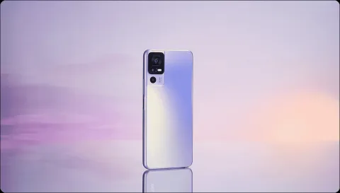 TCL 40 SE in Lavender, back view against a pastel sunset background