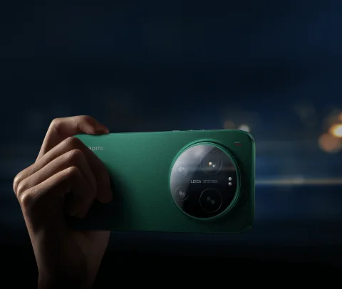 Hand holding the Xiaomi 17 Ultra in Starlit Green at night