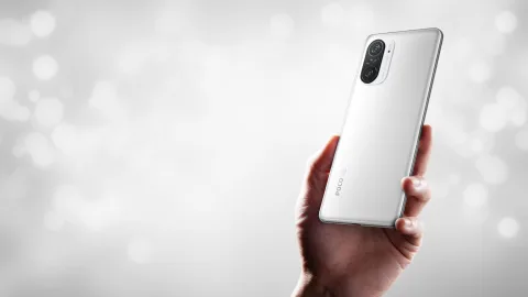 POCO F3 in White, held in hand showing back view