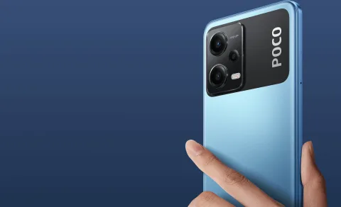 POCO X5 5G in Blue, held in hand showing the back panel and camera module